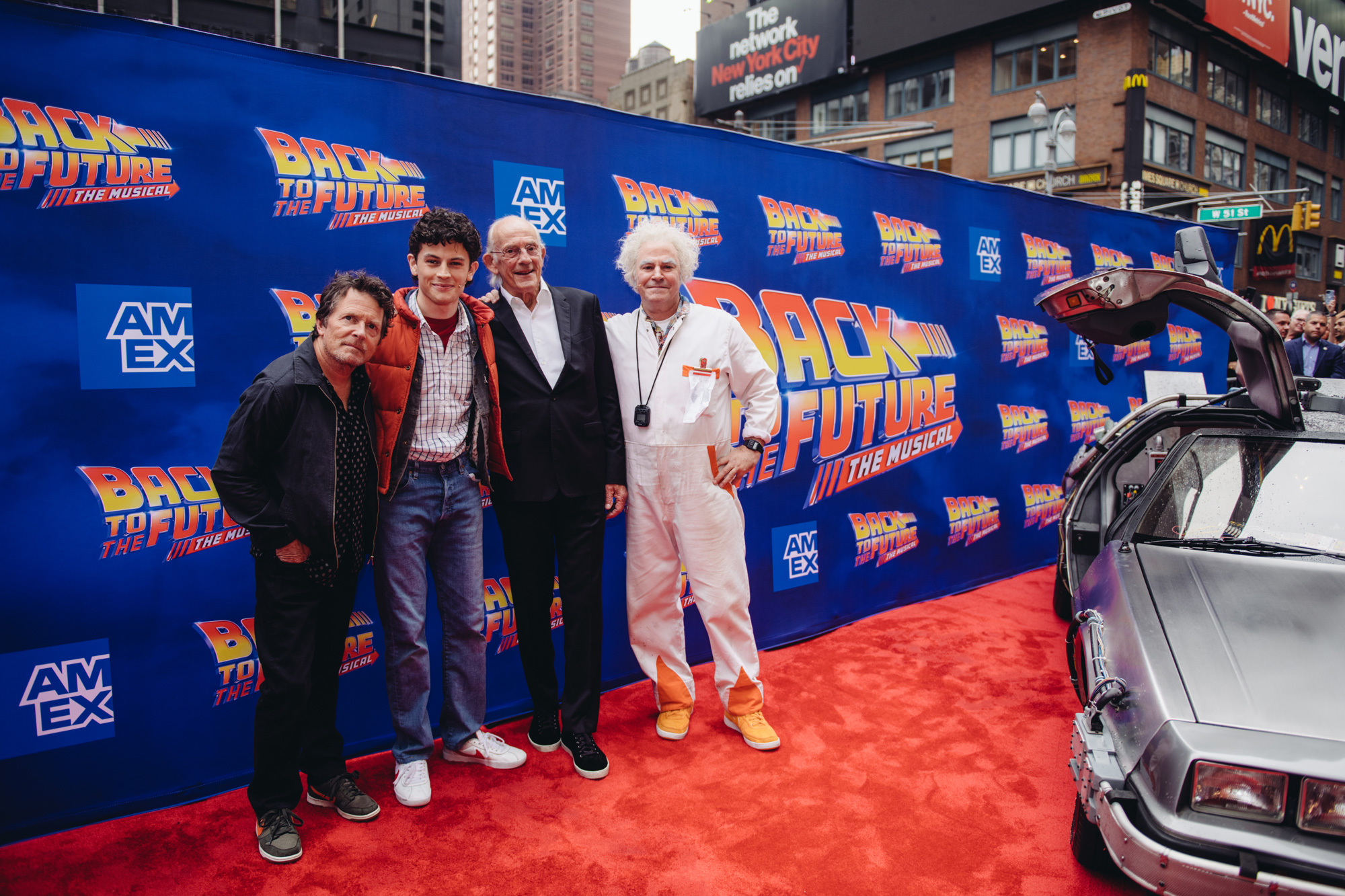 Michael J. Fox, Marty, Christopher Lloyd, and Doc standing next to the DeLorean at the Back to the Future Musical Gala
