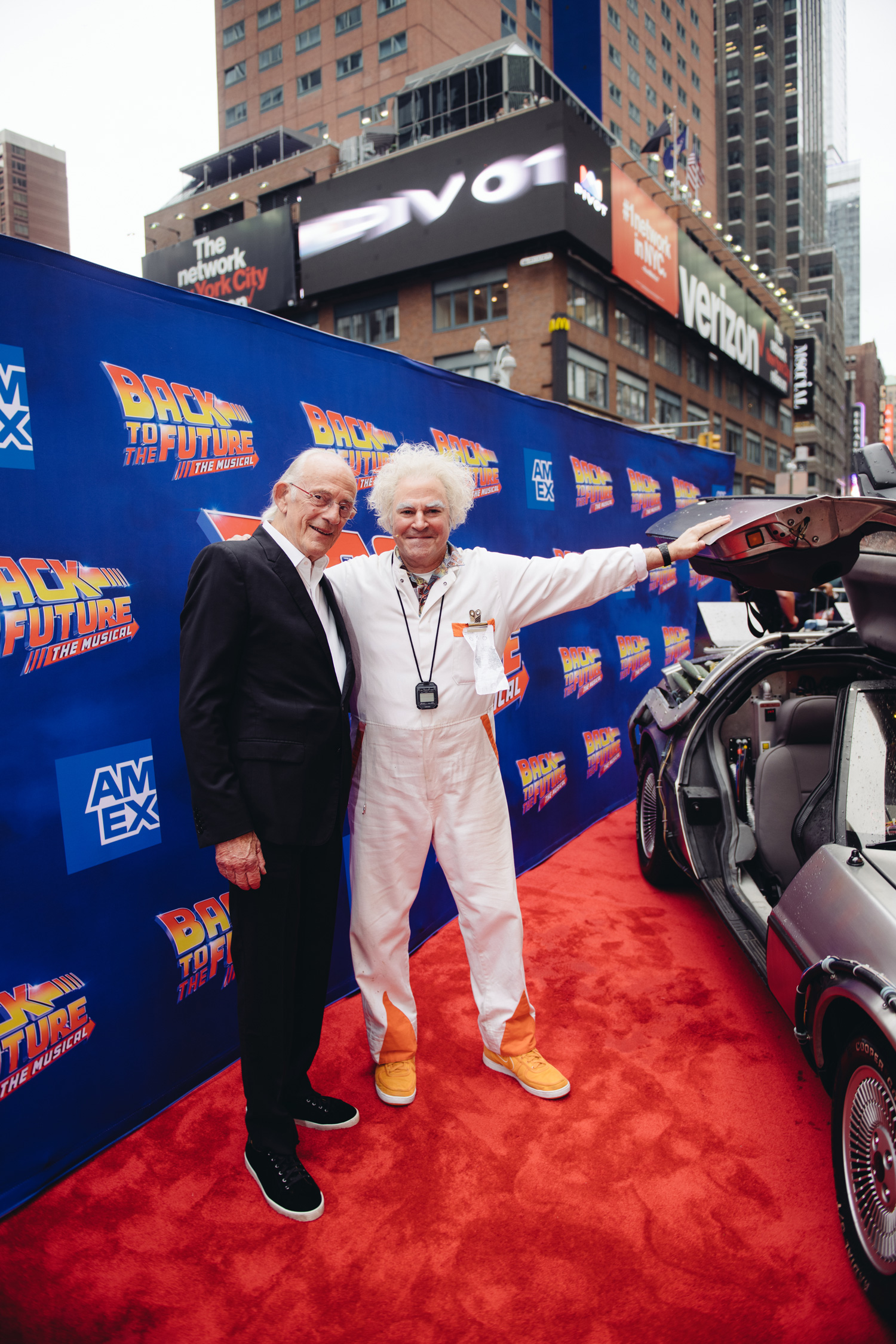 Christopher Lloyd and Roger Bart standing next to the DeLorean at the Back to the Future Musical Gala 